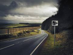 Panneau de signalisation à côté d'une route (Julian Calverley) - Muzeo.com